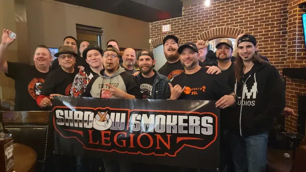 Members together holding the Shadow Smokers Legion banner